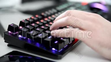 白天用手机和发光的鼠标在RBG机械键盘上特写手写。 抢劫